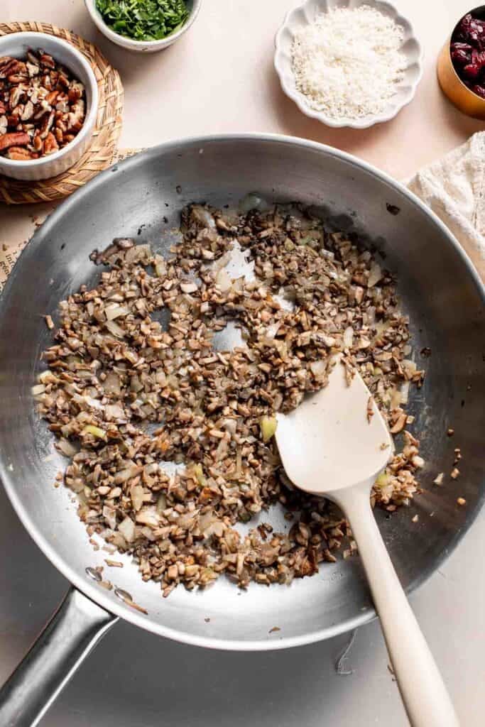Stirring the seasoned mushroom mixture with a spatula.