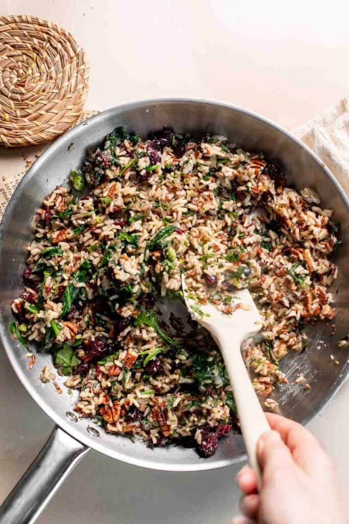 Stirring the wild rice stuffing ingredients together in the skillet.