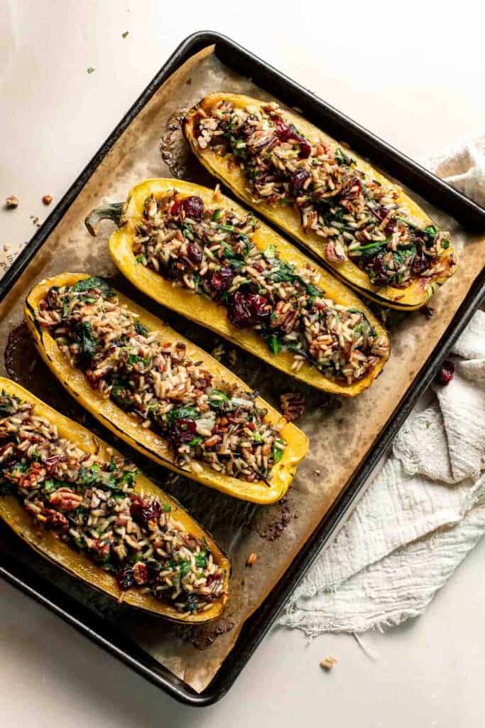Stuffed delicata squash halves with the filling mounded on top, ready to bake.