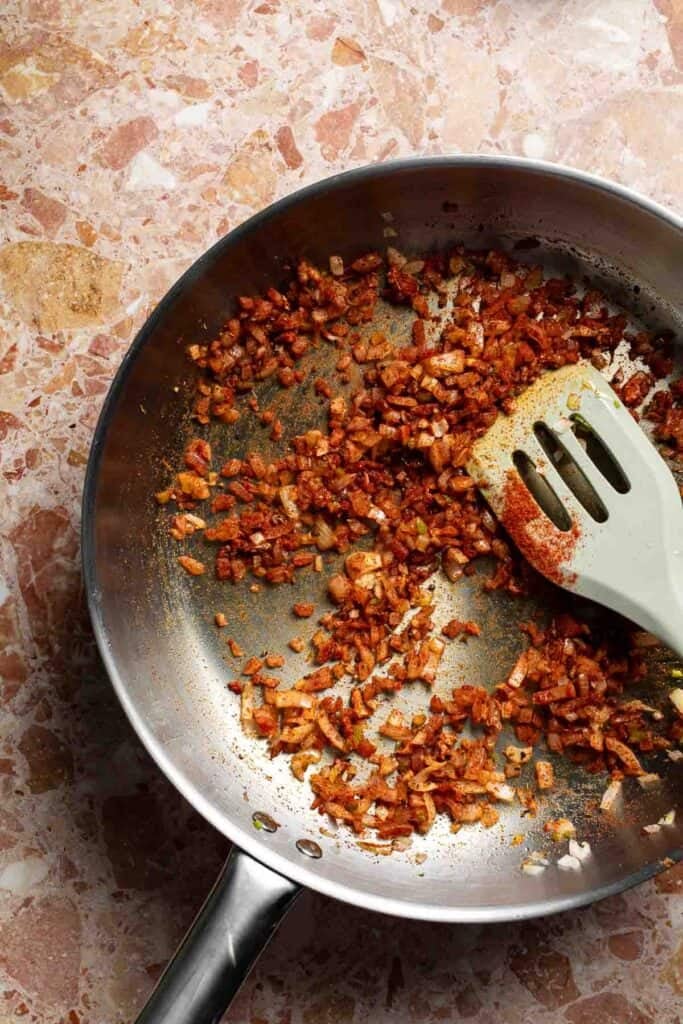 Onion, jalapeño, and spices cooked into a fragrant, deeply colored mixture in the skillet.