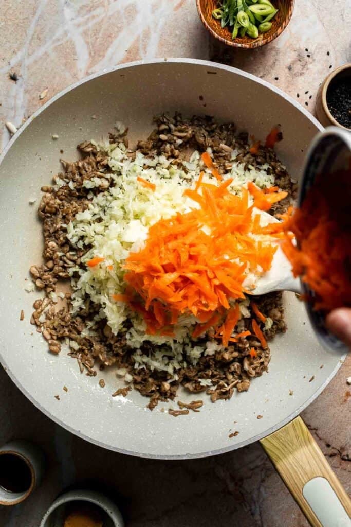 Shredded carrot added on top of the cabbage and mushrooms.