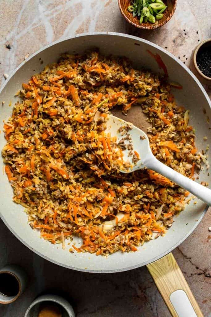 Cabbage, carrot, and mushrooms cooked down together in the skillet.