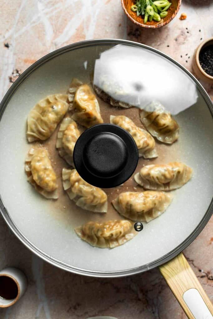 Water into the skillet of gyoza and covered with a lid to steam.