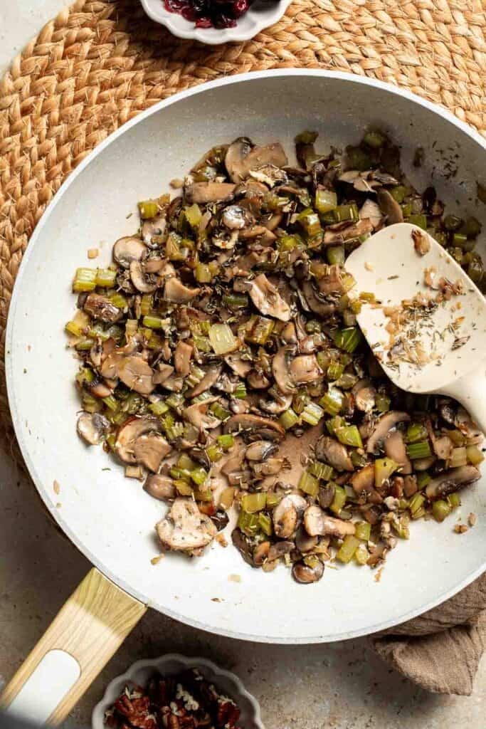 Stirring the seasonings into the mushroom and vegetable mixture until fragrant.