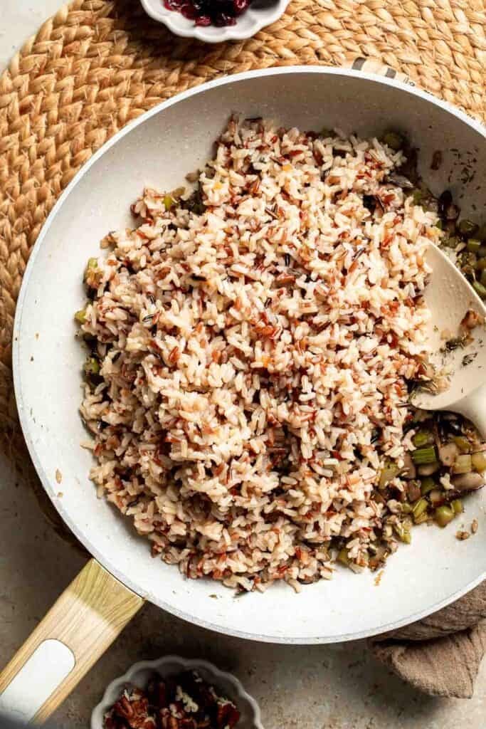 Cooked wild rice added to the skillet with the sautéed vegetables.