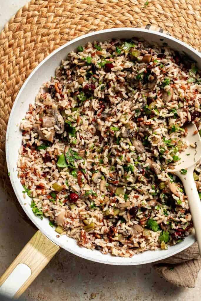 Wild rice stuffing stirred with fresh parsley in the skillet.