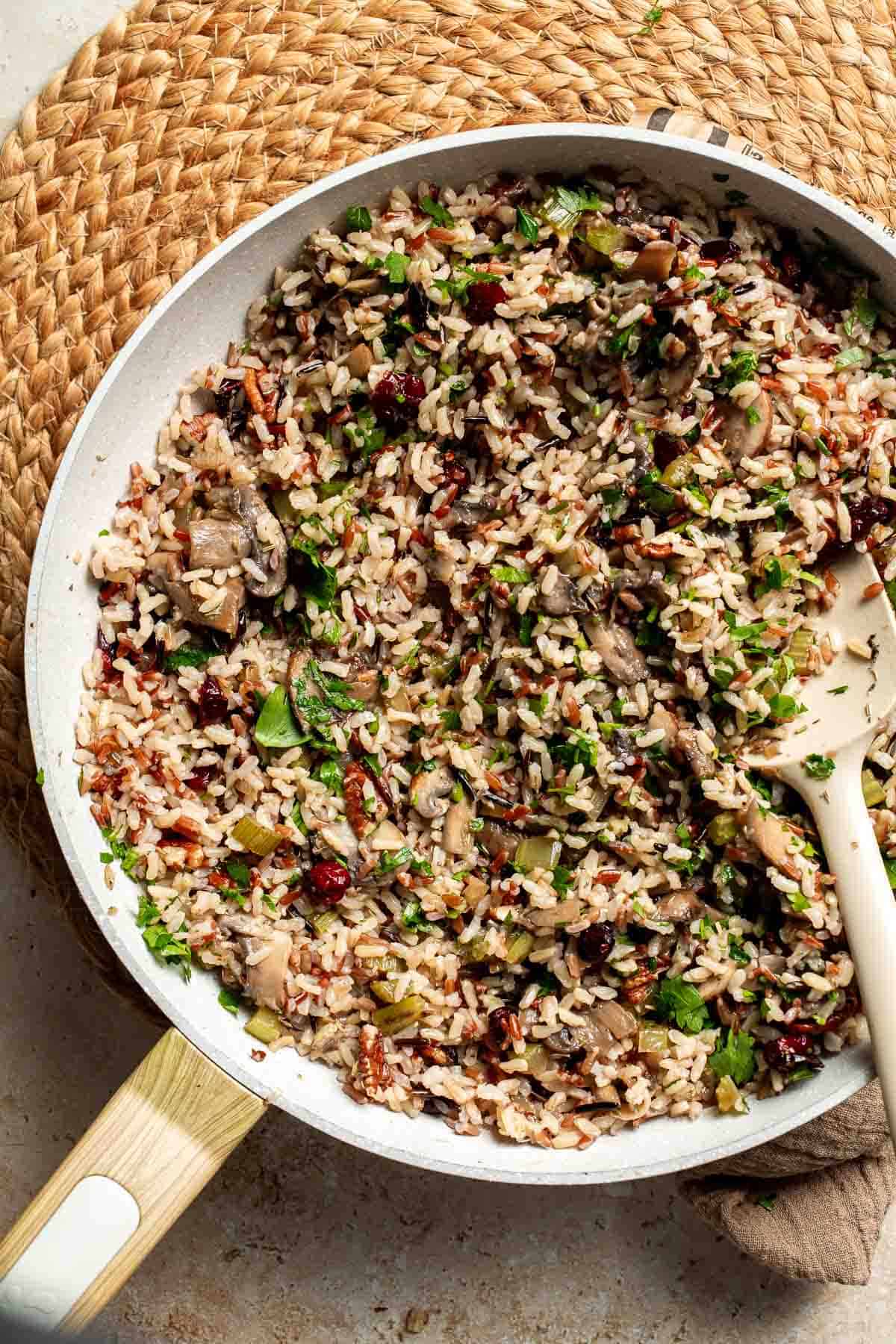 Wild rice stuffing stirred with fresh parsley in the skillet.